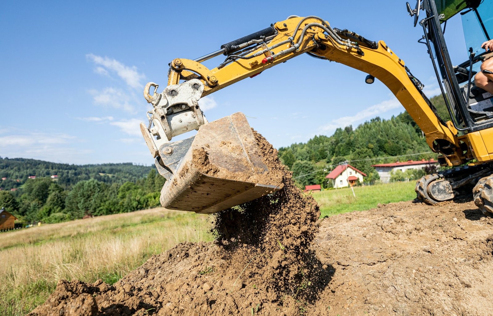 Mini excavator digging preparing ground under home garden